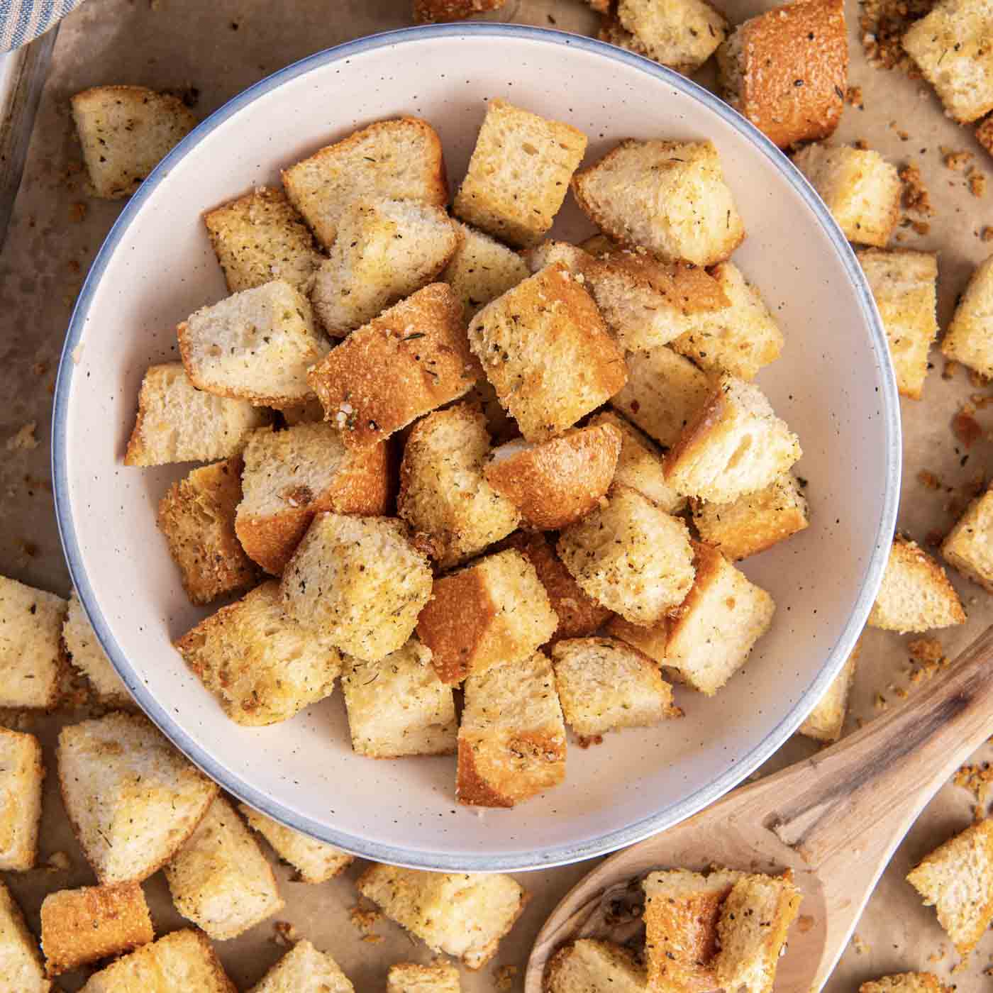 Bowl of croutons set on baking sheet.